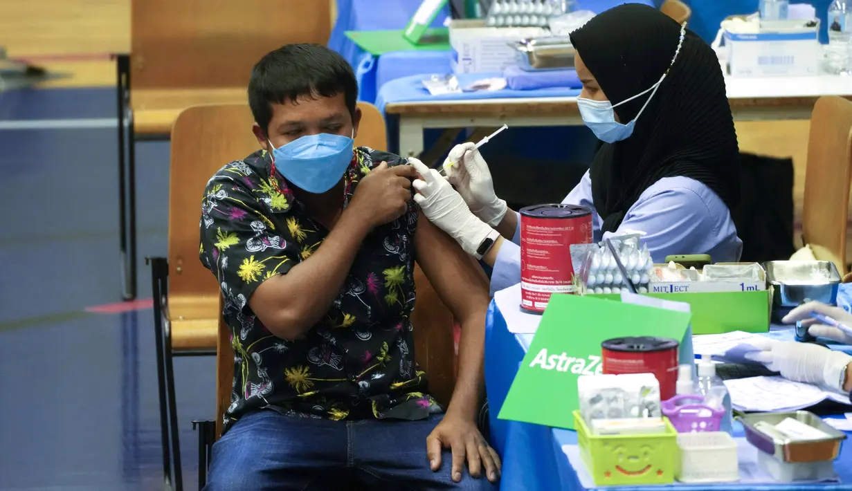 Petugas kesehatan memberikan vaksin COVID-19 AstraZeneca kepada seorang pria di Bangkok, Thailand, 23 Februari 2022. Thailand akan melonggarkan beberapa persyaratan masuk bagi turis asing untuk membangun kembali yang rusak akibat pandemi ekonomi mulai 1 Maret mendatang. (AP Photo/Sakchai Lalit)