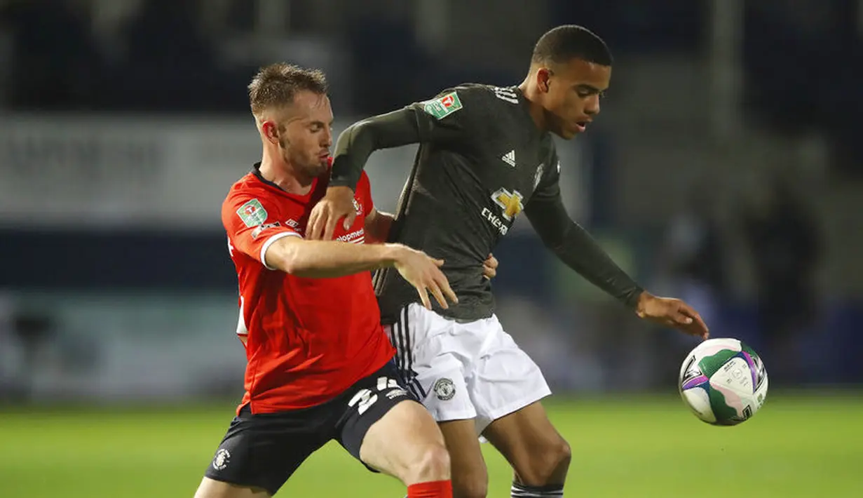 Pemain Manchester United, Mason Greenwood, berebut bola dengan pemain Luton Town, Rhys Norrington-Davies , pada Piala Liga Inggris di Stadion Kenilworth Road, Rabu (23/9/2020). Setan Merah menang dengan skor 3-0. (Nick Potts/Pool via AP)