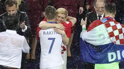 Kolinda Grabar-Kitarovic memeluk Ivan Rakitic usai laga final Piala Dunia 2018 di Luzhniki Stadium, Moskow, Rusia, (15/7/2018). Meski Kroasia kalah Kolinda tetap tersenyum manis. (AP/Thanassis Stavrakis)