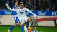Pemain Real Madrid, Kylian Mbappe, mencoba lepas dari penjagaan bek Deportivo Alaves saat kedua tim bertarung dalam lanjutan Liga Spanyol 2025/2025, Senin (15/12/2025) dini hari WIB. (AP Photo/Miguel Oses)