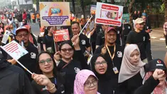 Peserta mengikuti pawai sosialisasi pengawasan Pilkada Serentak 2024 saat Hari Bebas Kendaraan Bermotor, Jalan MH Thamrin, Jakarta, Minggu (22/9/2024). (merdeka.com/Arie Basuki)