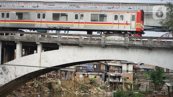 Kereta melintas di sekitar pemukiman bantaran Sungai Ciliwung, Jakarta, Jumat (17/7/2020). Badan Pusat Statistik menyebut tingkat kemiskinan di RI kini membengkak jadi 9,78 persen dari total populasi nasional akibat pandemi virus corona COVID-19. (Liputan6.com/Immanuel Antoniu)