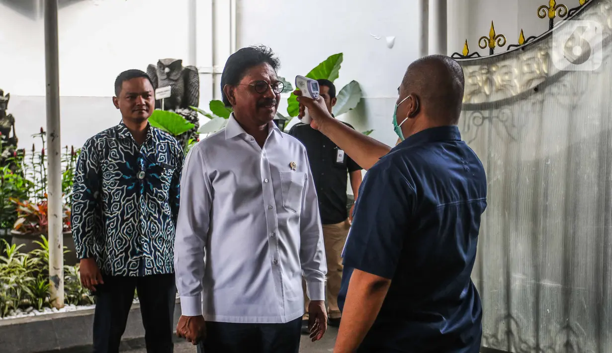Menkominfo Johnny G Plate menjalani pemeriksaan suhu tubuh saat akan memasuki Kompleks Istana Kepresidenan, Jakarta, Selasa (3/3/2020). Istana Kepresidenan memperketat pemeriksaan terhadap tamu, ASN, dan pejabat negara untuk mencegah penyebaran virus corona (COVID-19). (Liputan6.com/Faizal Fanani)