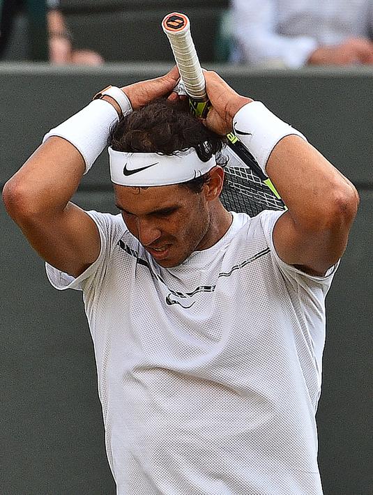 Petenis Spanyol, Rafael Nadal bereaksi saat melawan petenis Luksemburg, Giller Muller pada perempat final Wimbledon 2017 di London, Senin (10/7). Nadal dikalahkan Mueller dalam duel sepanjang lima set selama empat jam dan 47 menit. (Glyn KIRK / AFP)