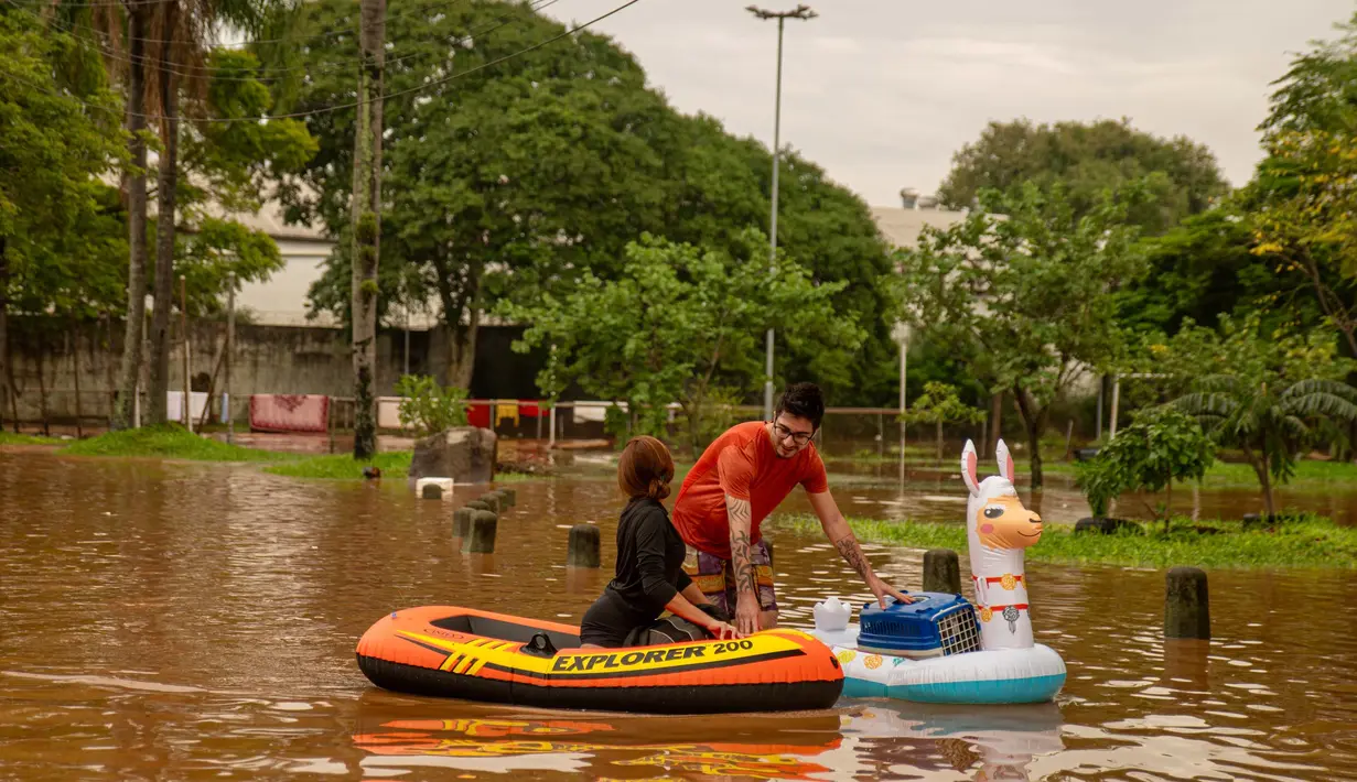 Pihak berwenang setempat dibantu sejumlah relawan langsung bergegas mengevakuasi warga yang tinggal di lingkungan Porto Alegre. (Carlos Fabal/AFP)
