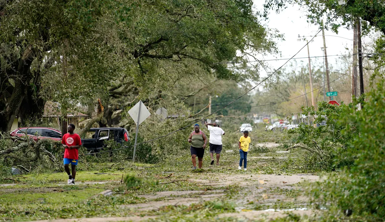 Orang-orang melihat dampak kerusakan di lingkungan mereka setelah Badai Laura menerjang kota pesisir Lake Charles, Louisiana, Amerika Serikat, Kamis (27/8/2020). Laura merupakan badai tingkat empat yang masuk kategori monster. (AP Photo/Gerald Herbert)