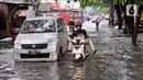 Kendaraan menerobos banjir yang menggenangi Jalan KH. Ahmad Dahlan Cipondoh, Tangerang, Selasa (16/2/2021). Hujan deras yang melanda wilayah Tangerang mengakibatkan ruas jalan alternatif penghubung Tangerang dengan Jakarta tersebut banjir setinggi lutut orang dewasa. (Liputan6.com/Angga Yuniar)