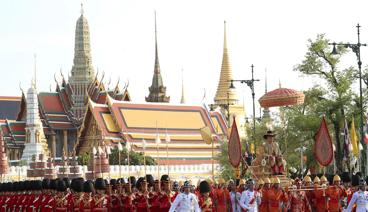 Raja Thailand Maha Vajiralongkorn diarak menggunakan tandu keliling Kota Bangkok, Thailand, Minggu (5/5/2019). Maha Vajiralongkorn diarak keliling Bangkok dengan tandu emas oleh para prajuritnya. (AP Photo/Rapeephat Sitichailapa)