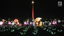 Pengunjung mengabadikan momen di depan salah satu lampion yang ditampilkan dalam Festival of Light di Monumen Nasional (Monas), Jakarta, Rabu (14/8/2019). (merdeka.com/Iqbal S. Nugroho)