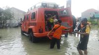 Petugas BPBD Gresik mengevakuasi korban banjir ke lokasi pengungsian. (Istimewa)