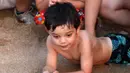 Seorang anak menyaksikan pelepasan tukik di pantai al-Mansouri dekat kota Tyre, Lebanon selatan (31/7/2019). Pelepasan ratusan anak penyu ini bagian pelestarian hewan yang terancam punah. (AFP Photo/Mahmoud Zayyat)