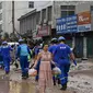 Petugas melakukan pembersihan di Gongyi, dekat Zhengzhou, provinsi Henan, China (22/7). (AFP)