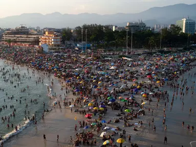 Foto udara menunjukkan orang-orang menikmati pantai Recreio dos Bandeirantes di tengah gelombang panas di Rio de Janeiro, Brasil, pada 17 Maret 2024. (TERCIO TEIXEIRA/AFP)