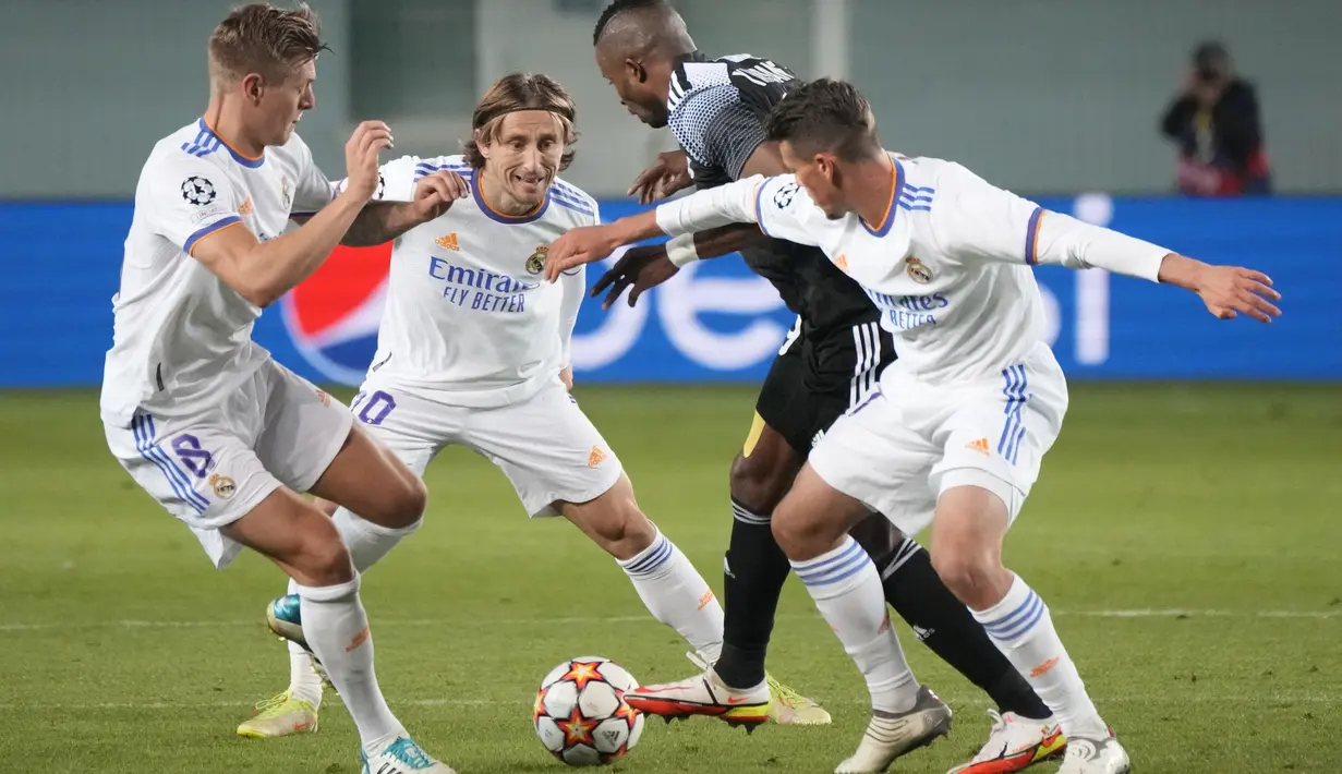 Penyerang Sheriff Tiraspol Momo Yansane berebut bola dengan gelandang Real Madrid Luka Modric dalam laga matchday 5 fase grup Liga Champions 2021/22 di Bolshaya Sportivnaya Arena, Kamis (25/11/2021) dini hari WIB. Real Madrid sukses menghajar Sheriff Tiraspol dengan skor 3-0. (AP Photo/Sergei Grits)