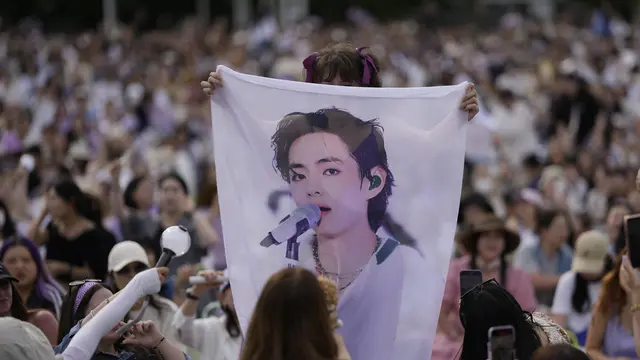 Seorang ARMY memegang poster V dalam BTS Festa 2023. ((AP Photo/Lee Jin-man)