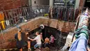 Orang-orang mengambil bagian dalam proses pembersihan di Bahia Blanca, 600 km sebelah selatan Buenos Aires, Argentina pada 10 Maret 2025. (PABLO PRESTI/AFP)