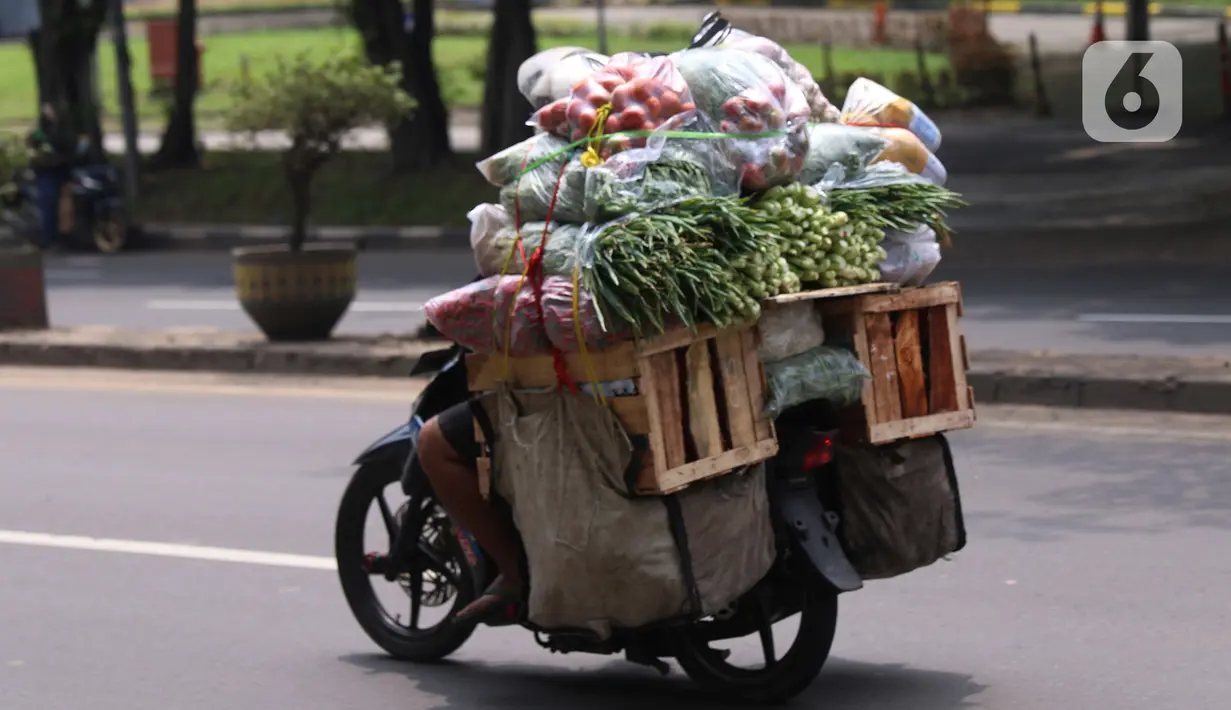Warga membawa bahan makanan dengan sepeda motor saat melintas di kawasan Tangerang, Banten, Rabu (16/2/2022).Bank Indonesia (BI) memperkirakan terjadi penurunan harga komoditas atau deflasi pada Februari 2022. (Liputan6.com/Angga Yuniar)