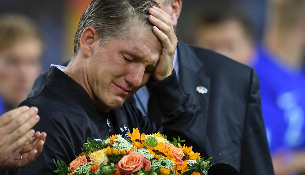 Bastian Schweinsteiger menangis saat mengucapkan salam perpisahan untuk fans dan timnas Jerman usai laga melawan Finlandia di Monchengladbach, Jerman (1/9/2016) dini hari WIB. (AFP/Patrik Stollarz)