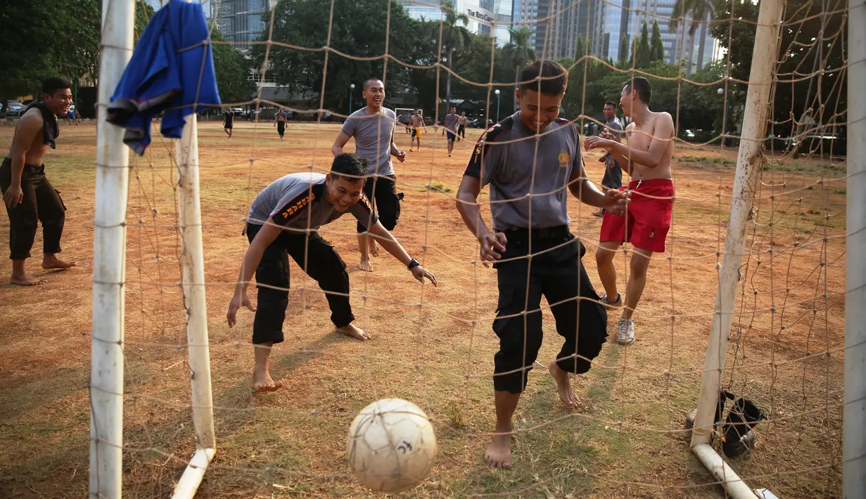 Polisi dari kesatuan Sabhara merenggangkan otot dengan bermain bola di Kawasan Polda Metro, Jakarta, Selasa (13/10/2015). Pihak Kepolisian dan TNI bersiap siaga menjelang laga Final Piala Presiden 2015. (Bola.com/Nicklas Hanoatubun).