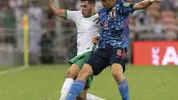 Gelandang Jepang, Wataru Endo berebut bola dengan pemain Arab Saudi, Sultan Al-Ghannam pada kualifikasi grup B zona Asia Piala Dunia Qatar 2022 di Stadion King Abdullah Sports City, Jeddah, Arab Saudi, Kamis (7/10/2021). Arab Saudi menang tipis atas Jepang 1-0. (AP Photo)