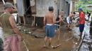 Warga bergotong royong membersihkan lumpur sisa banjir yang menutup jalan, Jakarta, Senin (7/11). Sebelumnya, ratusan rumah warga di RW 02 Cawang, Kramat Jati, Jakarta Timur tergenang akibat banjir kiriman dari kawasan Bogor. (Liputan6.com/Yoppy Renato)