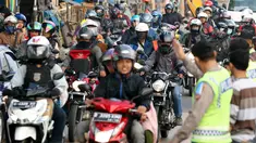 Polisi mengatur arus lalu lintas pemudik sepeda motor di Jalur Pantura Indramayu - Cirebon, Jawa Barat, Jumat (23/6). Iring-iringan pemudik bersepeda motor di sepanjang jalur pantura Indramayu - Cirebon mengular pada H-2 Lebaran (Liputan6.com/Johan Tallo)