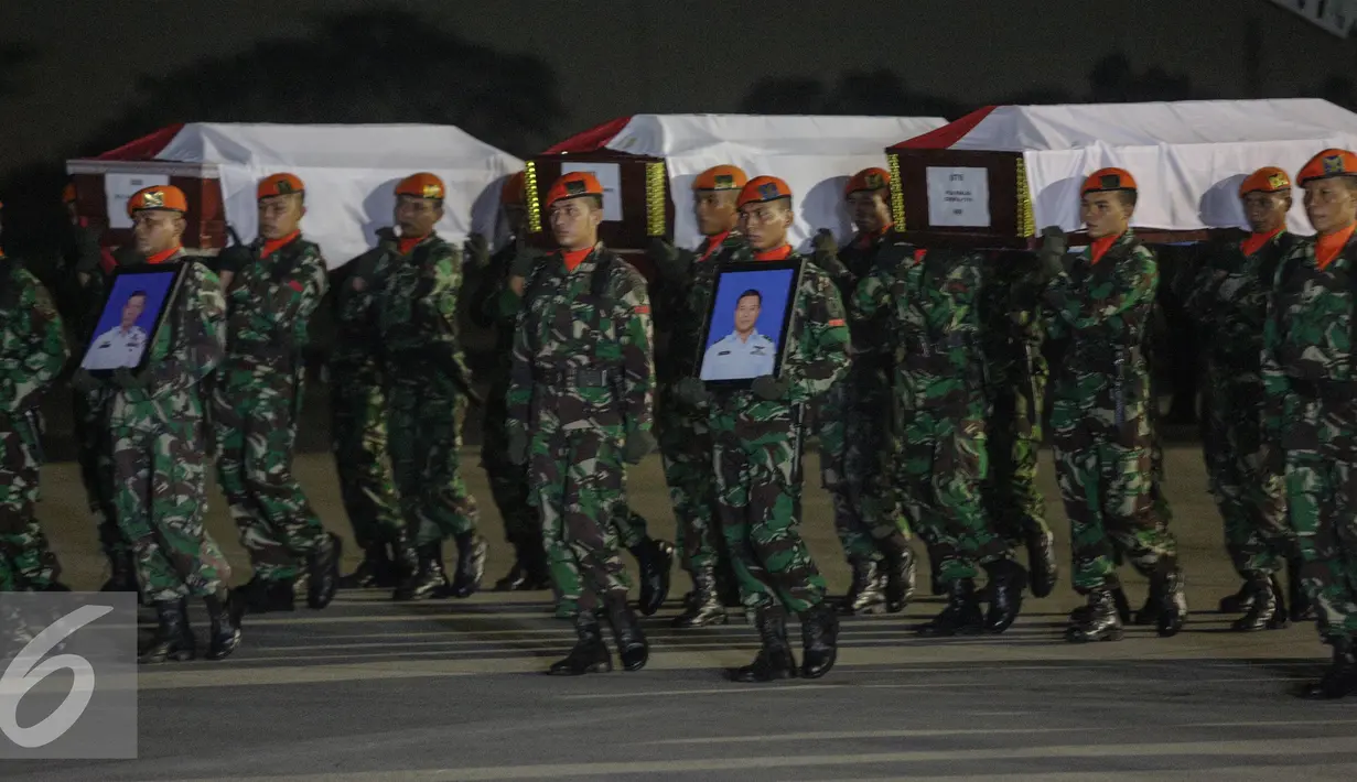 Puluhan prajurit membawa peti jenazah korban jatuhnya pesawat Hercules C-130, di Lanud Halim Perdanakusuma, Jakarta, Rabu (1/7/2015). Presiden Jokowi memimpin langsung upacara penerimaan jenazah. (Liputan6.com/Faizal Fanani)