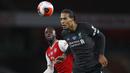 Bek Liverpool, Virgil van Dijk, berebut bola dengan gelandang Arsenal, Nicolas Pepe, pada laga lanjutan Premier League pekan ke-36 di Emirates Stadium, Kamis (16/7/2020) dini hari WIB. Arsenal menang 2-1 atas Liverpool. (AFP/Paul Childs/pool)