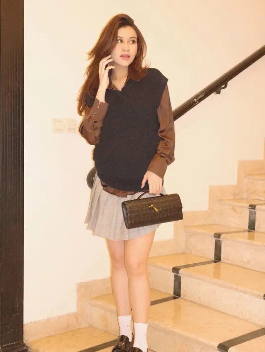 Sedang hamil besar, Aaliyah Massaid hadir totalitas sebagai Cher Horowitz di film Clueless. Aaliyah mengenakan vest hitam dipadukan inner kemeja lengan panjang coklat serta mini skirt pleated. Ia membawa tas hitam senada dengan warna sepatu  loafers yang dipadukan kaos kaki putih. [@aaliyah.massaid]