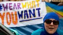 <p>Seorang wanita mengenakan burkini ketika mengadakan demonstrasi pesta pantai di luar kedutaan Prancis di London, Inggris, Kamis (25/8). Mereka memprotes larangan burkini yang diberlakukan di beberapa kota pesisir di Prancis. (AFP PHOTO/JUSTIN Tallis)</p>