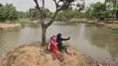 Anak-anak berselfie di danau Taman Cempaka, Cipayung, Jakarta Timur, Minggu (7/7/2019). Banyak warga yang datang secara rombongan dengan membawa alas tikar dan makanan. (merdeka.com/Iqbal S Nugroho)