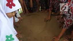 Murid SD melihat prasasti telapak kaki gajah di Prasasti Kebun Kopi, Ciaruteun Ilir, Bogor, Jawa Barat, Rabu (15/8). Prasasti ini peninggalan budaya Kerajaan Tarumanegara yang berdiri pada abad 4 hingga 7 masehi di Pasundan. (Merdeka.com/Arie Basuki)