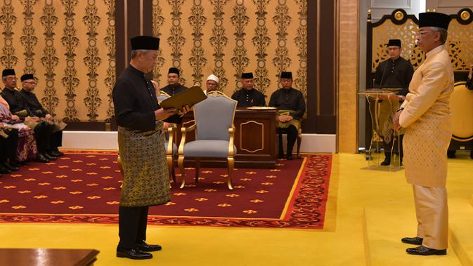 Muhyiddin Yassin (kiri) menyatakan sumpah di depan Raja Sultan Abdullah Sultan Ahmad Shah (kanan) saat upacara pelantikannya sebagai PM Malaysia, Istana Negara, Kuala Lumpur, Minggu (1/3/2020). Muhyiddin Yassin menjadi PM ke-8 Malaysia. (MASZUANDI ADNAN/MALAYSIA'S DEPARTMENT OF INFORMATION/AFP)