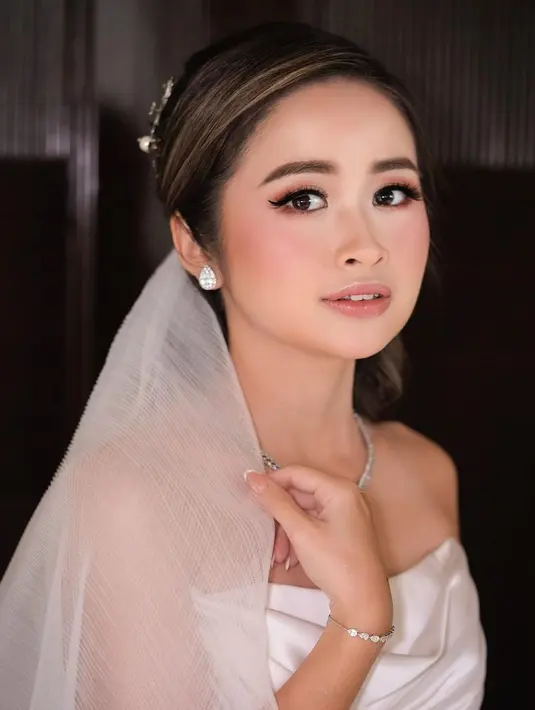 Area kelopak mata dan pipi tampak dipoles eyeshadow dan blush on warna senada. Sementara bibirnya diaplikasikan warna yang sesuai dengan warna bibir alaminya.  [Instagram/victoria_makeupatelier]