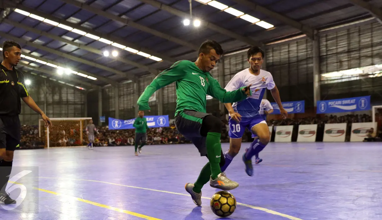 Pemain Timnas Futsal Indonesia, Ardiansyah (tengah) mencoba melewati pemain IPC Pelindo II saat laga uji coba di Jakarta, Minggu (15/1). Timnas Futsal Indonesia akan melakoni laga piala AFF 2017, akhir Januari. (Liputan6.com/Helmi Fithriansyah)