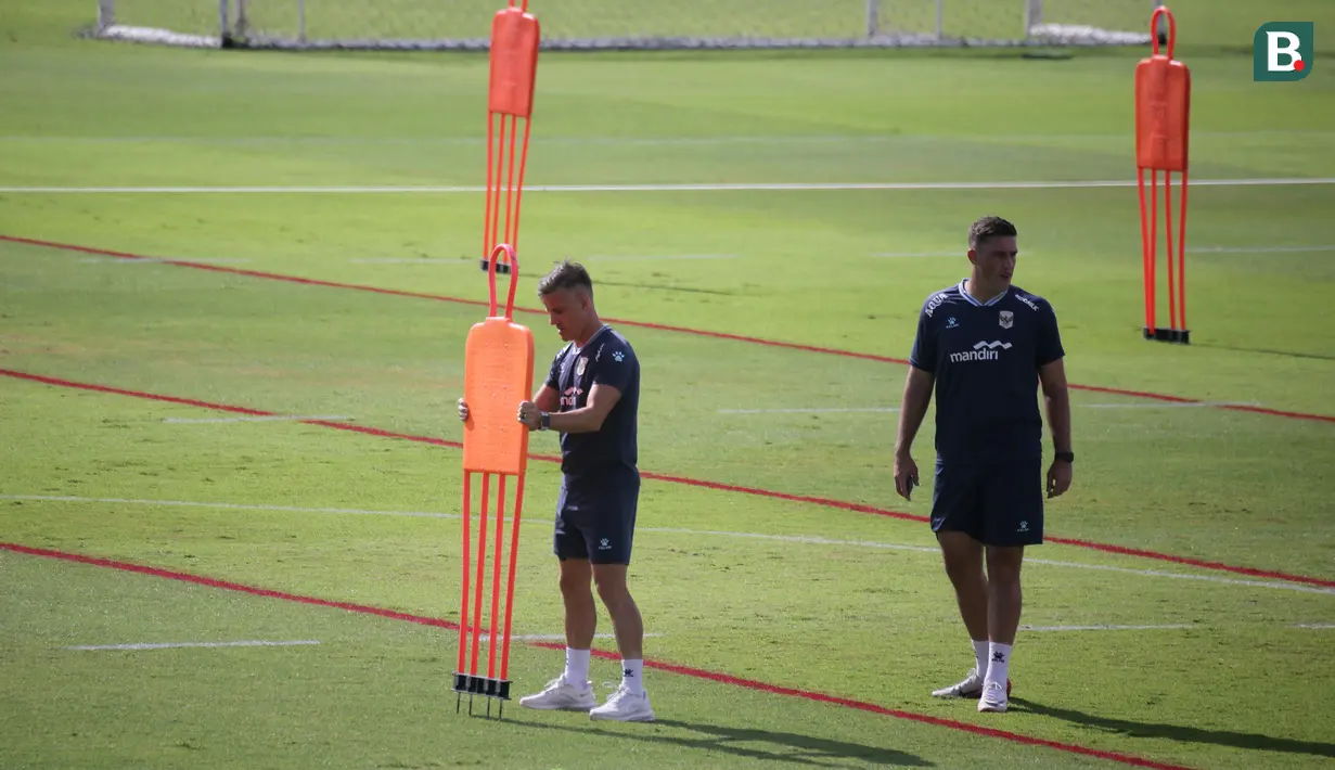 Pelatih Timnas Indonesia, John Herdman (kiri), bersama staf pelatih menyiapkan perlengkapan saat sesi latihan di Bali United Training Center, Gianyar, Bali, Kamis (23/7/2026). John Herdman terus mematangkan persiapan Skuad Garuda yang memasuki pekan terakhir pemusatan latihan jelang menghadapi Kamboja pada laga perdana Grup A Piala AFF 2026 di Stadion Pakansari, Bogor, 27 Juli 2026. (Bola.com/Alit Binawan)