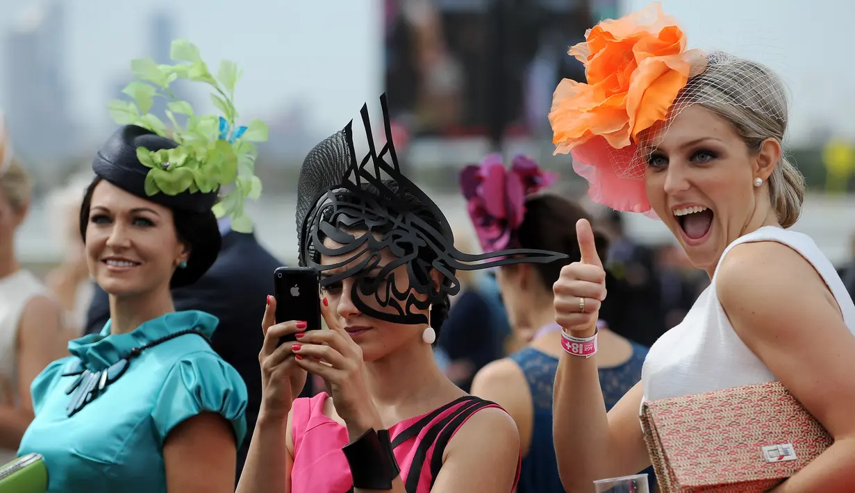 Sekumpulan wanita berfoto bersama saat menghadiri balap kuda Melbourne di arena pacuan kuda Flemington Racecourse di Melbourne, Australia (1/11). Acara ini berlangsung dari September hingga pertengahan November. (AFP/Paul Crock)