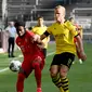 Bek Bayern Munchen, Alphonso Davies, mengawal ketat penyerang Borussia Dortmund, Erling Haaland, pada laga pekan ke-28 Bundesliga di Signal Iduna Park, Rabu (27/5/2020). (AFP/Federico Gambarini/POOL)