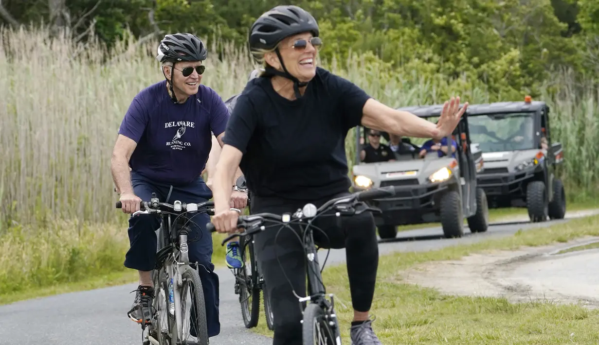 Presiden Joe Biden bersama ibu negara, Jill Biden bersepeda di Pantai Rehoboth, Delaware, Kamis (3/6/2021). Mereka bersepeda sekaligus untuk merayakan ulang tahun ke-70 ibu negara Amerika Serikat. (AP Photo/Susan Walsh)