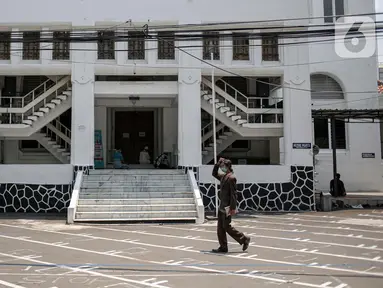 Warga berjalan di halaman depan Masjid Cut Meutia, Jakarta, Jumat (18/9/2020). Pemprov DKI Jakarta kembali meniadakan kegiatan ibadah salat Jumat dan salat lima waktu berjemaah di semua Masjid Raya selama PSBB. (Liputan6.com/Faizal Fanani)