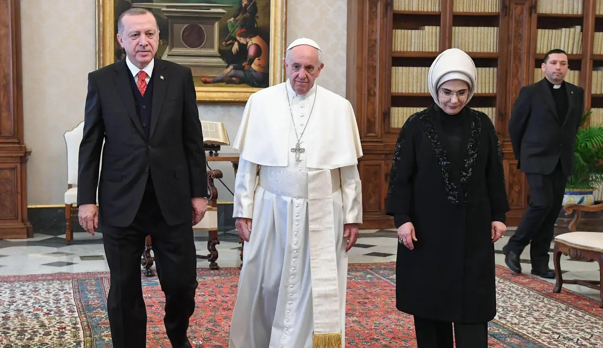 Presiden Turki Erdogan berjalan bersama Paus Fransiskus saat kunjungannya ke Vatikan (5/2). Baik Erdogan maupun Paus Fransiskus menyatakan menentang keputusan Donald Trump untuk mengakui Yerusalem sebagai Ibu Kota Israel. (Alessandro Di Meo / Pool via AP)