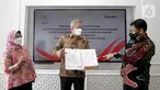 Direktur Hubungan Kelembagaan Bank Mandiri Rohan Hafas (tengah) menunjukkan naskah MoU Kerjasama Kemensetneg dan Bank Mandiri saat berbincang dengan SVP Government Solutions Dwi Rihandjani (kiri) dan Corporate Secretary Rudi As Aturridha di Jakarta, Kamis (15/7/2021). (Liputan6.com/HO/Mandiri)