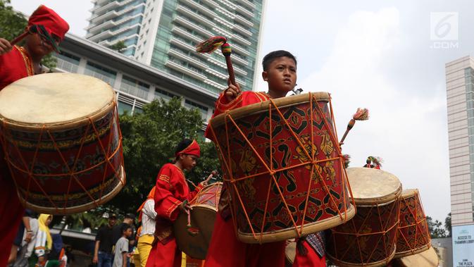 Seniman cilik memainkan alat musik tambur khas Minangkabau saat car free day (CFD) di Jakarta, Minggu (13/1). Pertunjukan tersebut untuk mengenalkan alat musik tradisional Nusantara kepada masyarakat. (Liputan6.com/Angga Yuniar)