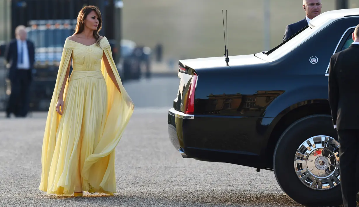 Ibu Negara AS, Melania Trump menghadiri acara makan malam di Bleinheim Palace, Inggris, Kamis (12/7). Melania mengenakan gaun berdetail off shoulder dengan aksen cape lengan panjang yang menutupi tangannya. (Geoff Pugh/Pool via AP)