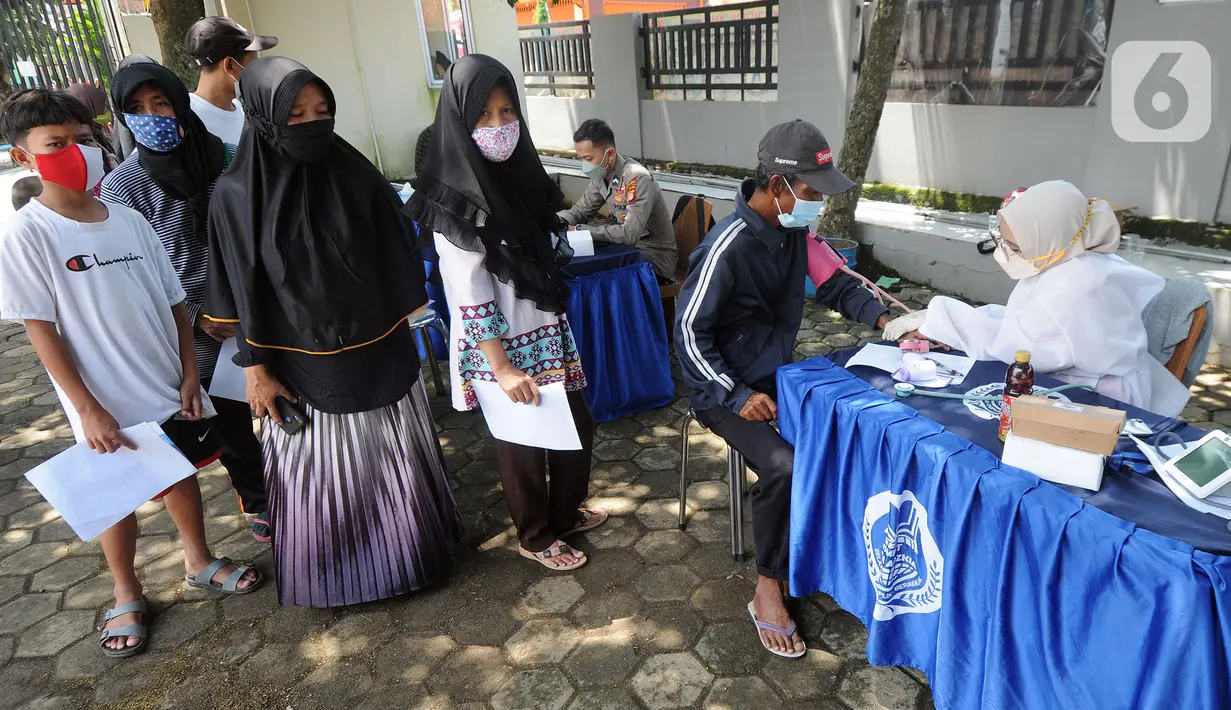 Warga Kelurahan Serua antre mendapatkan suntikan pertama vaksin COVID-19 Sinovac di musala Pesantren Nurul Hidayah, Serua, Kota Depok, Jawa Barat, Rabu (22/9/2021). Kegiatan Vaksinasi Merdeka ini dalam rangka menyukseskan program vaksinasi nasional. (merdeka.com/Arie Basuki)