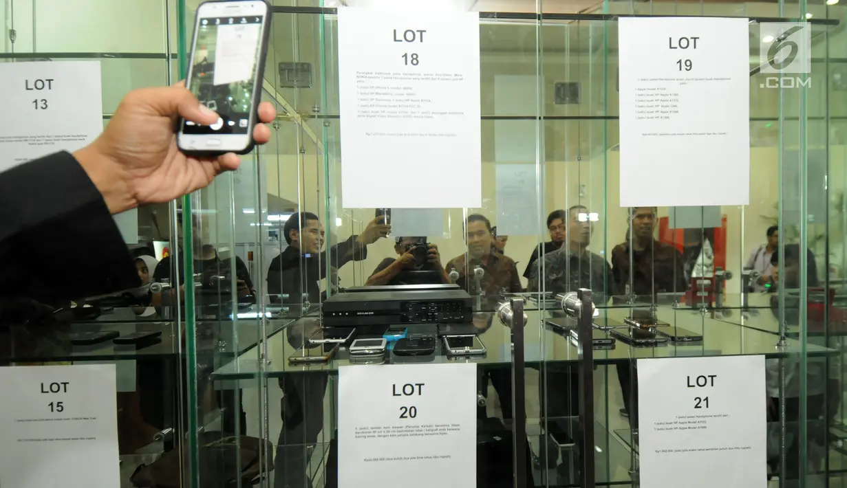 Sejumlah awak media mengabadikan deretan handphone (HP) berbagai jenis di intalasi yang akan dilelang di gedung KPK, Jakarta, Jumat (20/7). Handphone tersebut hasil sitaan KPK terhadap para koruptor yang ketangkap KPK. (Merdeka.com/Dwi Narwoko)