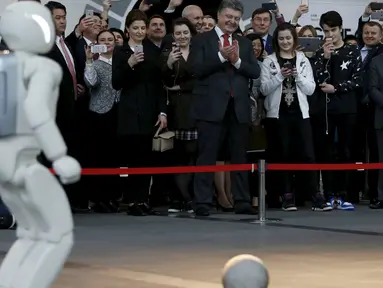 Robot humanoid buatan Honda motors Asimo saat beraksi bermain bola di Miraikan, Tokyo , Jepang , (7/4). Pertunjukan tersebut juga dihadiri oleh Presiden Ukraina Petro Poroshenko dan mantan astronot Mamoru Mori. (REUTERS / Issei Kato)