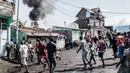 Kepanikan warga saat sebuah pesawat jatuh di kawasan padat penduduk, Goma, Republik Demokratik Kongo, Minggu (24/11/2019). Pesawat tersebut jatuh tak lama setelah lepas landas. (PAMELA TULIZO/AFP)