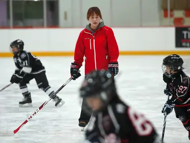 Mantan atlet hoki es Korut, Hwangbo Young melatih anak-anak selama kelas hoki di gelanggang es di Seoul (4/4). Hwangbo berharap bisa menjadi pelatih tim hoki es wanita nasional Korea Selatan pada Olimpiade musim dingin 2018. (AFP Photo / Jung Yeon-Je)