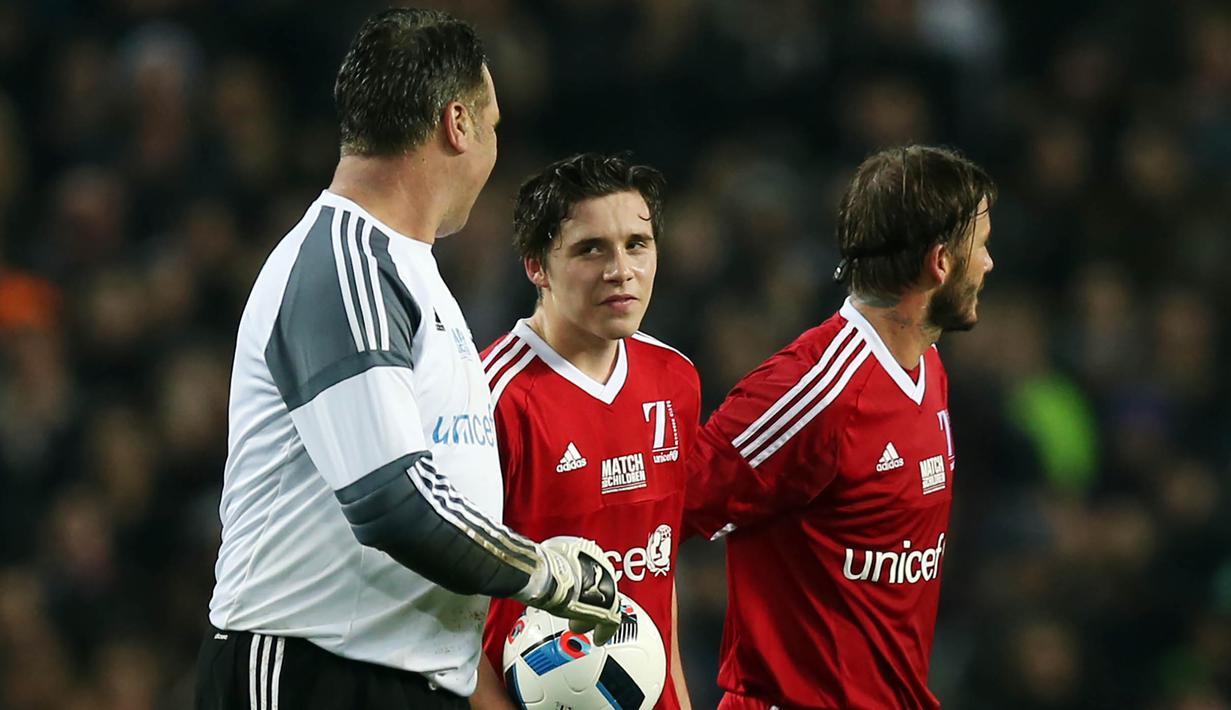 Pemain Great Britain & Ireland XI, Brooklyn Beckham, berdiskusi dengan Kiper, David Seaman, saat bertanding pada laga amal melawan World XI di Old Trafford, Inggris, Sabtu (14/11/2015) dini hari WIB. (Action Images via Reuters/Alex Morton)